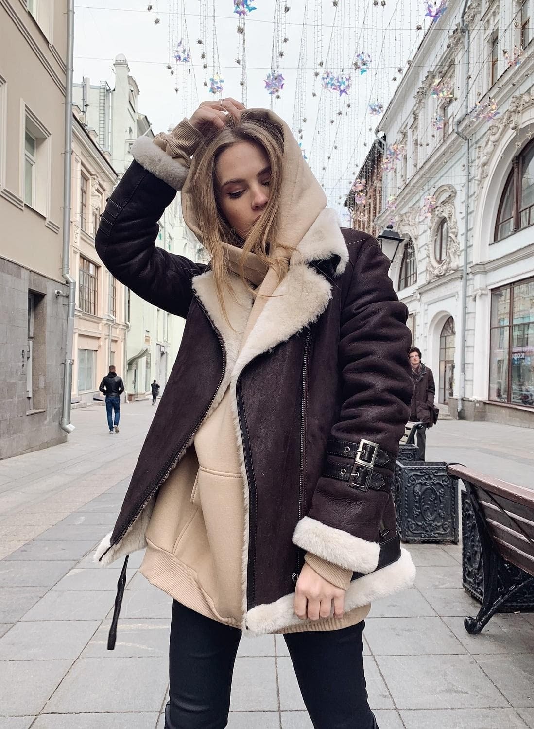 Коричневая дубленка авиатор с белым мехом и черными лосинами